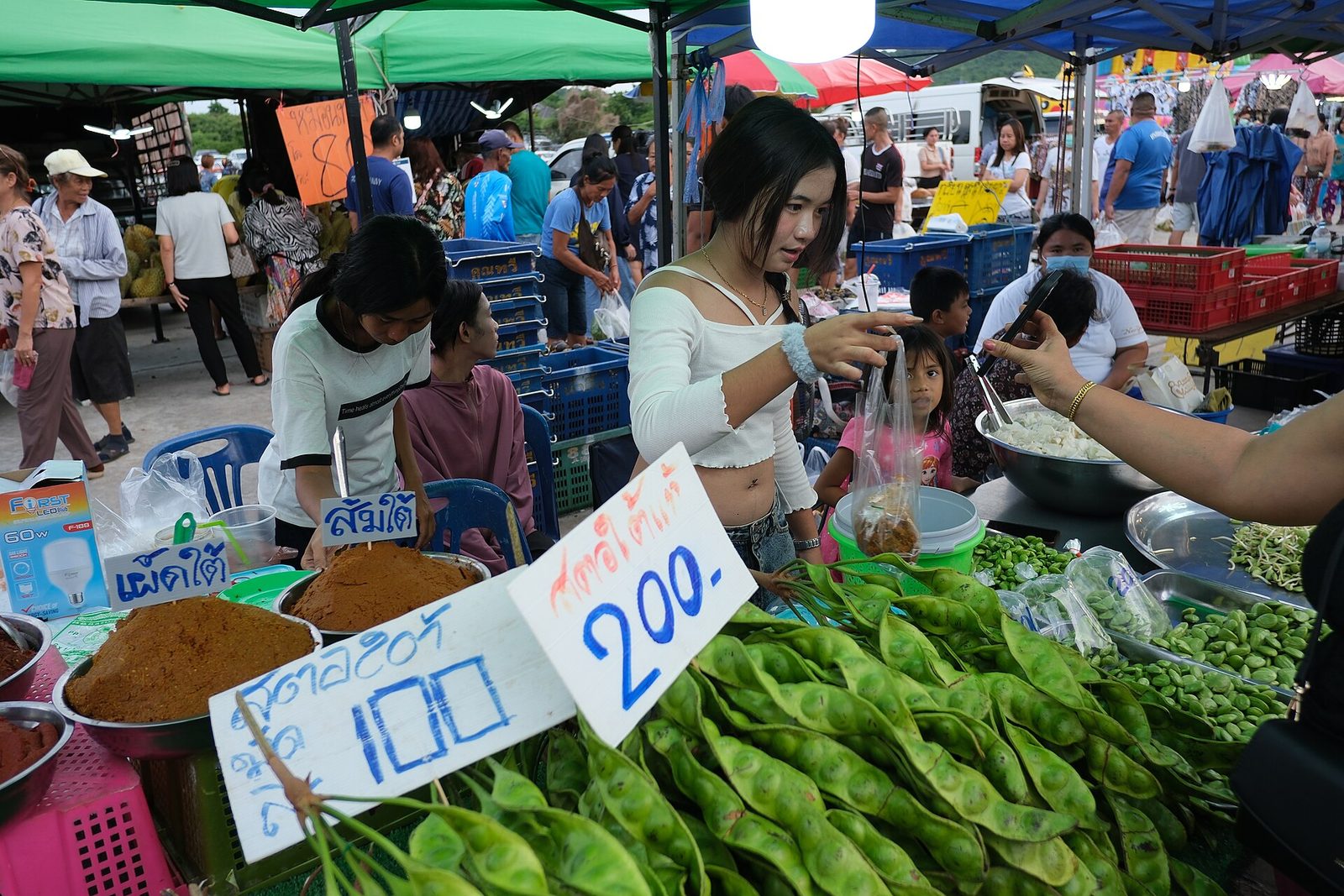 แผงผัก-ผลไม้ในตลาดธุรกิจขนาดย่อม ผู้ค้ากำลังจัดสินค้าให้ลูกค้า